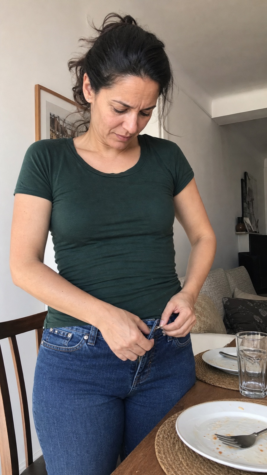 Escena recreada de una mujer intentando abrocharse el pantalón después de comer